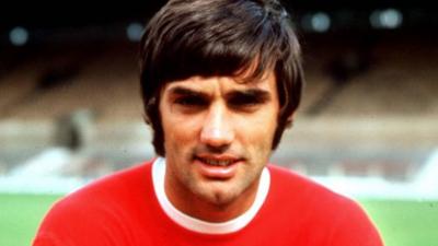 George Best poses in a Manchester United shirt