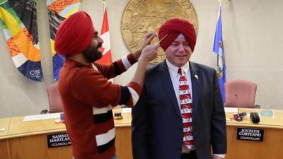 Gurdeep Pandher fits Mayor Dan Curtis with a turban