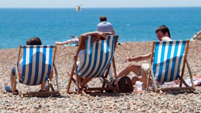 Sunbathers enjoying warm weather on the beach.