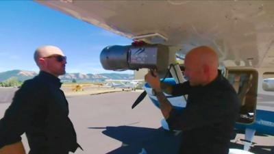 Two men inspecting a device