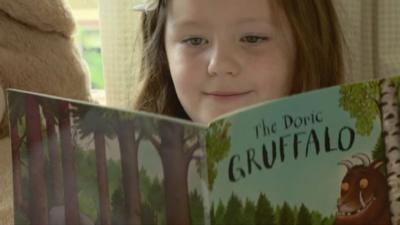 Girl reading The Doric Gruffalo