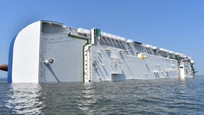 The US Coastguard has made contact with four missing crew members of a cargo ship that capsized.