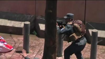 A police officer aims his rifle during the protests