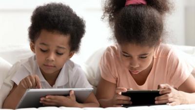 Two children looking at tablet computer screens