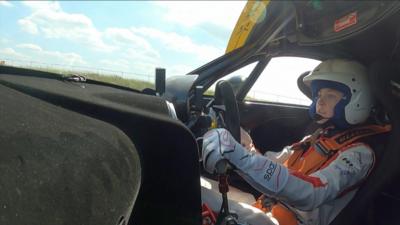 Female driver in a racing car.