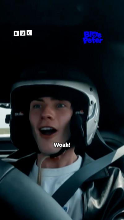 Joel racing in an aston martin.
