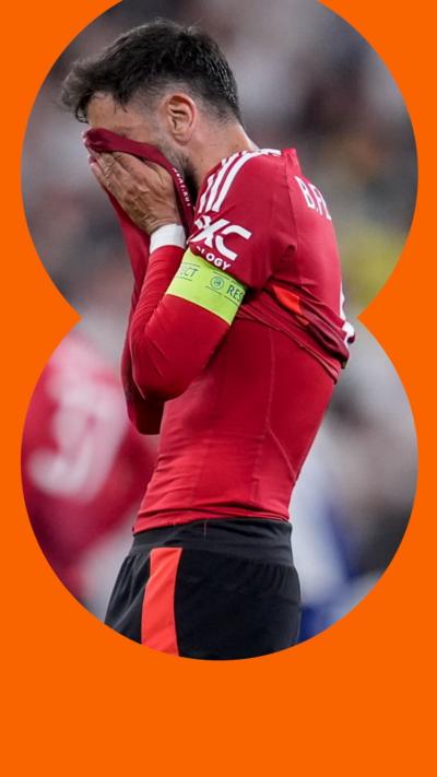 Manchester United's Bruno Fernandes covers his face with his shirt on the pitch