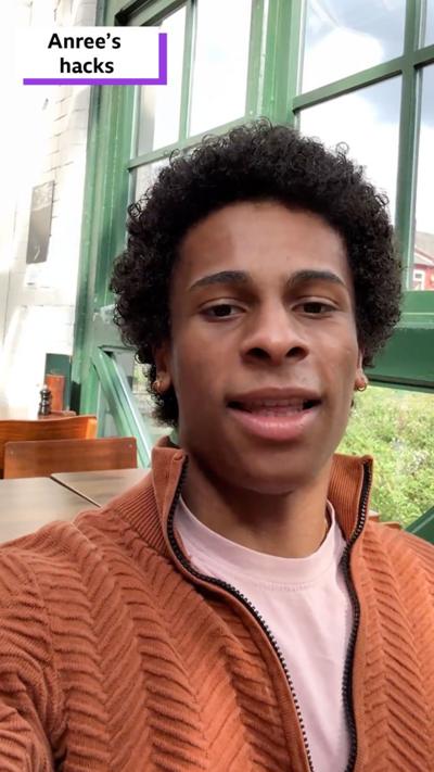 Anree, a young man in a jumper, sits in a cafe