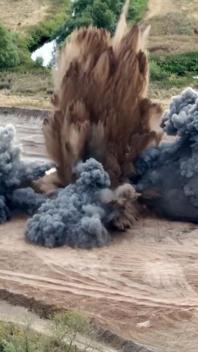 Ex ploding brown and grey soil after a wartime bomb is detonated