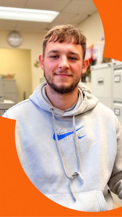 25-year-old youth worker Karl, in a grey hoodie, sitting in the youth centre