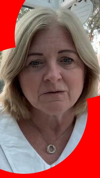 A woman with shoulder-length blonde hair looks at the camera