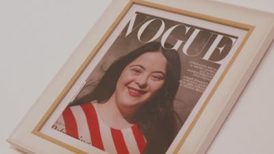 ellie's vogue cover framed on her wall shows her smiling wearing a colourful outfit