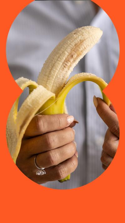 A woman's hands peel a banana with yellow skin