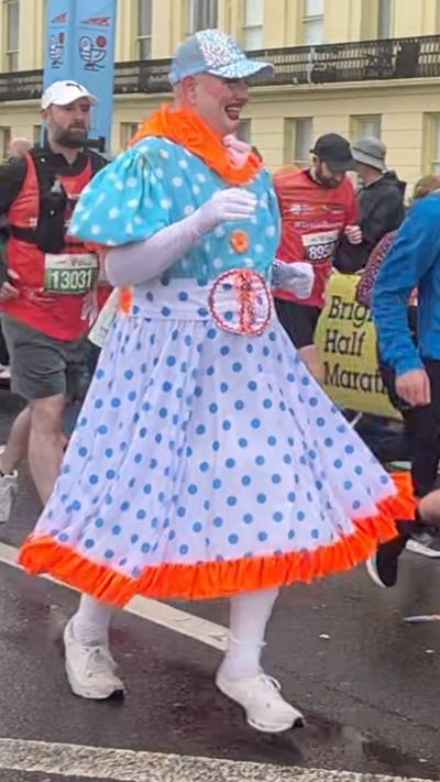 A man in a spotted dress running the half marathon
