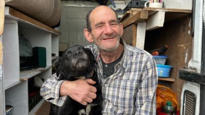 Man with his arms around a dog