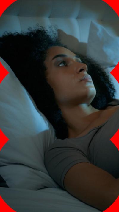 A woman with dark hair lies in bed