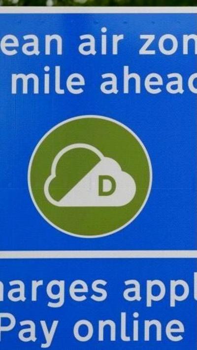 a blue sign with white lettering and a green circle with a clean air symbol