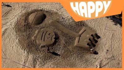 Giant sand sculptures and the Happy logo
