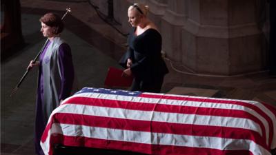 Meghan McCain walks the past the casket of her father