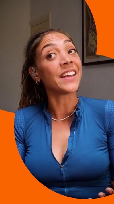Miquita, wearing blue, and looking to the side while speaking