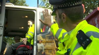 A police officer waves to cyclist Philippa Gregory who's sat in the driver's cab.