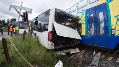 The wreckage of a school bus and a train stand on a railway crossing near Buxtehude, northern Germany