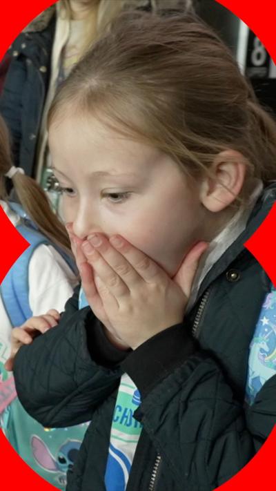 A school girl has her hands over her mouth in shock