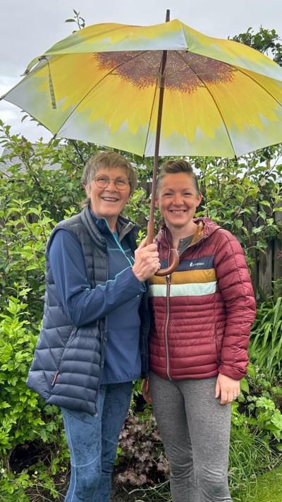 Two women underneath an umbrella 
