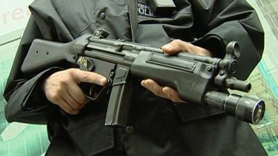 Armed police officer with large gun