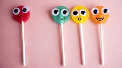 Green lollipop with Cartoon Eyes on Pink Colored Background