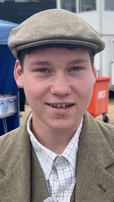 A young farmer in a flat cap and tweed jacket 