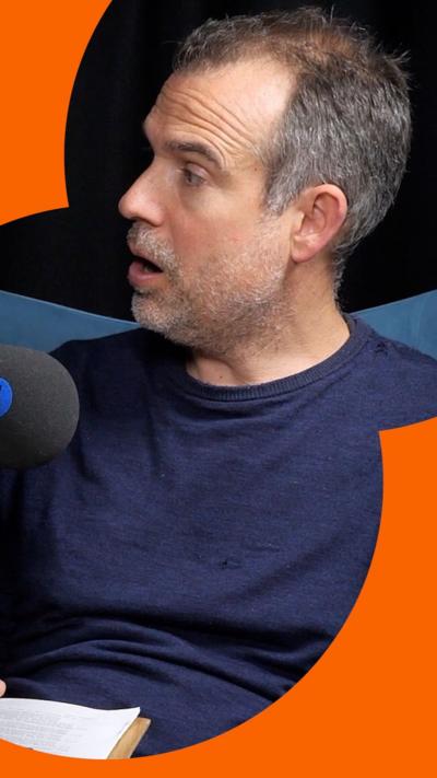 A man with short, grey hair looks at someone off-camera