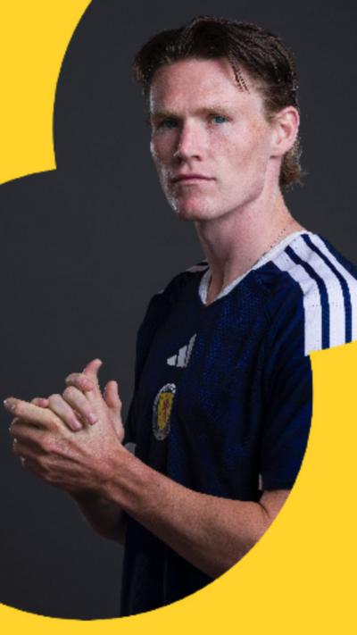 Scott McTominay is wearing a Scotland kit and has his hands clasped together