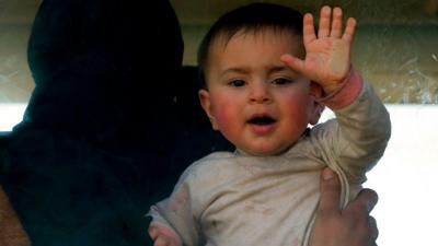 Baby waves through bus window during Eastern Ghouta evacuation