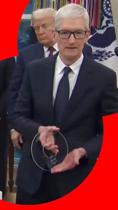 Apple's Tim Cook, wearing a suit, holding a glass disk in the Oval Office, with President Trump behind him. 