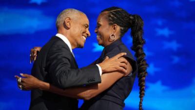 Barack and Michelle Obama hug on stage at DNC