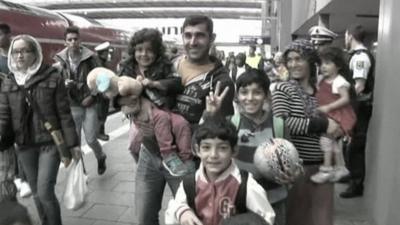 Refugees arrive on a station platform