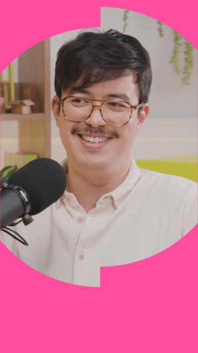 Phil Wang has short dark hair and is wearing glasses and a cream shirt.