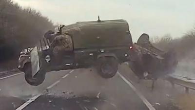 Land Rover and trailer roll through the air on an A-road.
