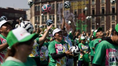 Crowds tossing football in Mexico's City Zocalo Square