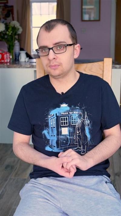 A man in a blue t shirt with glasses