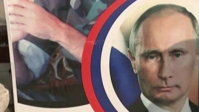 A taxi driver holding a picture of Vladimir Putin