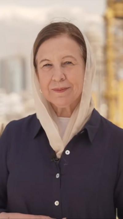 Lyse Doucet in a beige headscarf and blue shirt