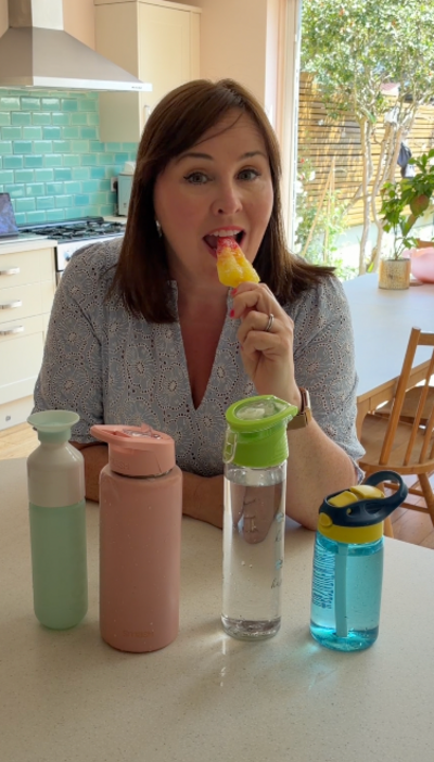 woman eats icecream in front of bottles of water