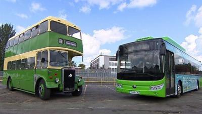 An old fashioned bus next to a new style bus