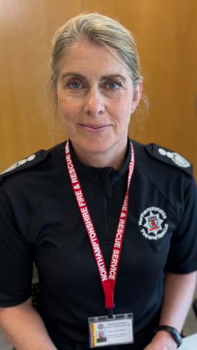 Nikki Watson, Chief Fire Officer, looks directly to camera. She is wearing a black top and a has a white lanyard. 