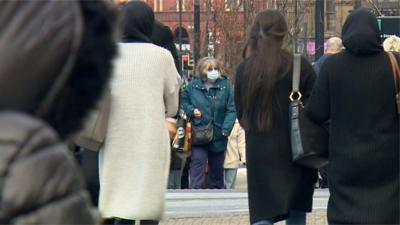 Woman wearing face mask in crowd