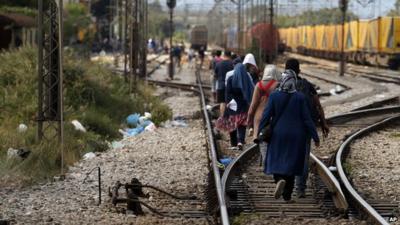 Migrants walk towards the railway station in the Macedonian town of Gevgelija