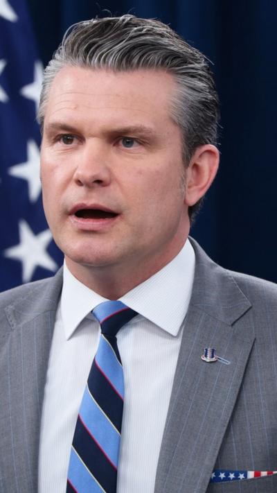 Hegseth wearing a suit and a tie 