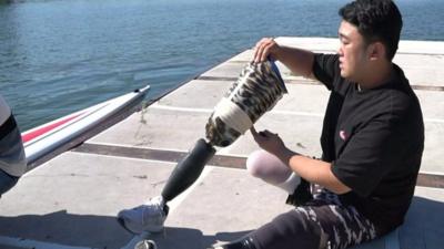 Ha Jae-heon fits his prosthetic legs next to his boat